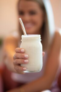 woman holding glass jar of healthy smoothie