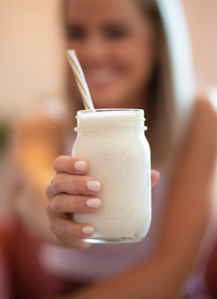 woman holding glass jar of healthy smoothie